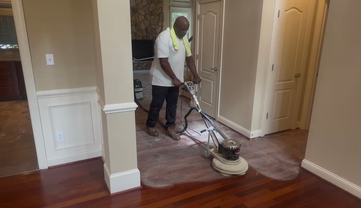 Buffing a hardwood floor next to finished cherry flooring